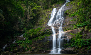 Waterfall flowing through the lush Atlantic Forest at Tijuca National Park in Rio de Janeiro, Brazil, one of the world’s largest urban rainforests.