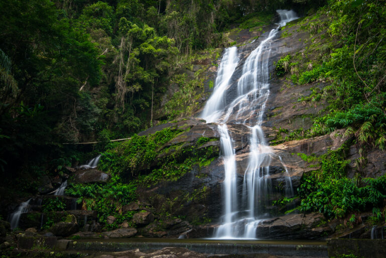 Waterfall flowing through the lush Atlantic Forest at Tijuca National Park in Rio de Janeiro, Brazil, one of the world’s largest urban rainforests.