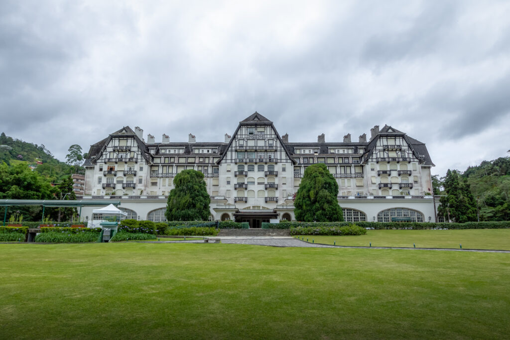 Front view of the Quitandinha Palace in Petrópolis, Rio de Janeiro, Brazil, a historic landmark of the Imperial City surrounded by green hills.